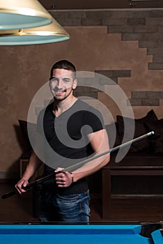 Portrait Of A Young Male Model Playing Billiards