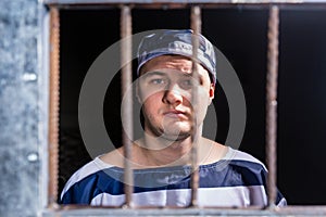 Portrait of young male prisoner wearing prison uniform standing