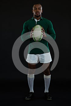 Portrait of young male rugby player holding ball