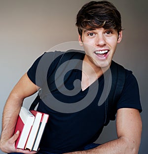 Portrait of a young male student with books