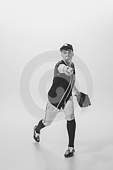 Portrait of young man, baseball player, pitcher with bubblegum playing, serving ball. Black and white photography