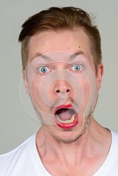 Portrait of young man with beard stubble wearing makeup