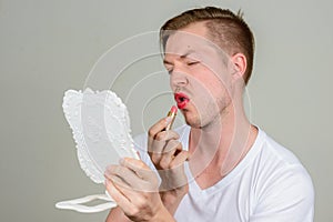 Portrait of young man with beard stubble wearing makeup