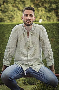 Portrait of a young man. Bearded man posing. Man wearing a green linen shirt. Surrounded by nature