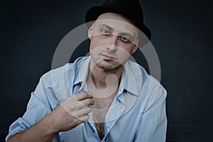 Portrait of a young man with a black hat making a classic gesture of Italian culture which in most cases means `what do you want`?