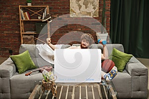 Portrait of young man with blank sign like social media screen sitting at home.