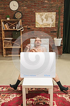Portrait of young man with blank sign like social media screen sitting at home.