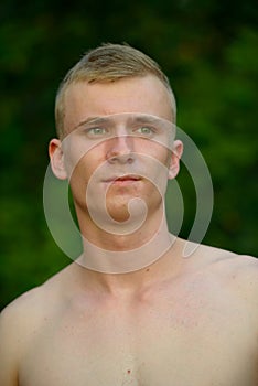 Young man with blond hair shirtless at the park outdoors