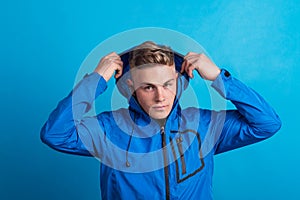 Portrait of a young man with blue anorak in a studio. Copy space.