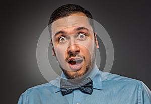 Portrait young man in blue shirt, looking with amazement