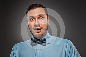 Portrait young man in blue shirt, looking with amazement