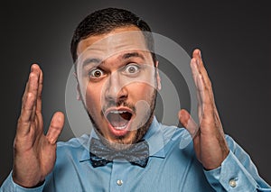 Portrait young man in blue shirt, looking with amazement