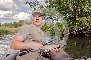 Portrait of a young man in a boat with a spinning rod