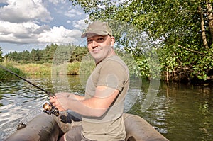 Portrait of a young man in a boat with a spinning rod