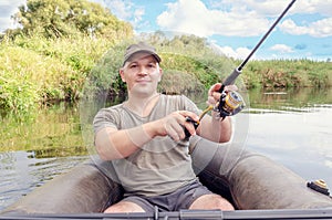 Portrait of a young man in a boat with a spinning rod