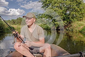 Portrait of a young man in a boat with a spinning rod