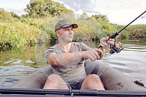 Portrait of a young man in a boat with a spinning rod