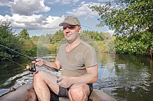 Portrait of a young man in a boat with a spinning rod