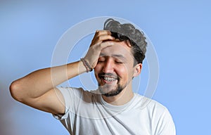 Portrait of a young man with braces smiling. A happy young man with braces on a blue background