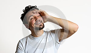 Portrait of a young man with braces smiling. A happy young man with braces on a white background