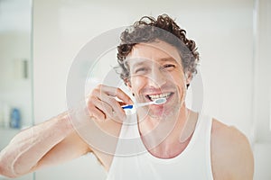 Portrait of young man brushing teeth