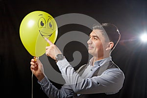 Portrait of a young man in a business suit and wigh with balloons. Positive guy posing in the studio