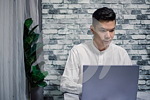 Portrait of young man businessman working at office with laptop on desk