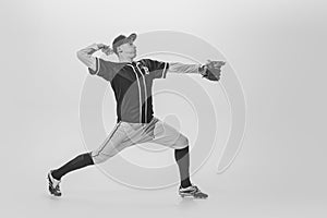 Portrait of young man, college student, baseball player, pitcher training, serving ball. black and white photography