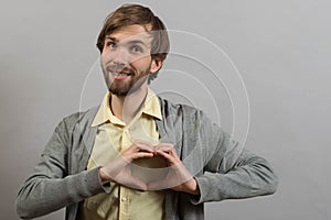Portrait of young man doing heart gesture