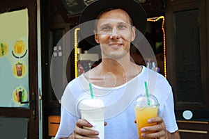 Portrait of young man drink cold drink and milkshake in the streets outdoors.