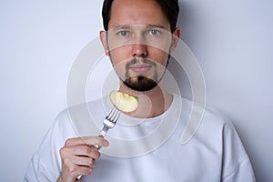 Portrait of a young man eating a piece of apple