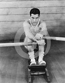 Portrait of a young man exercising on a rowing machine