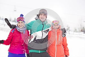 Portrait of young man with female friends enjoying in snow