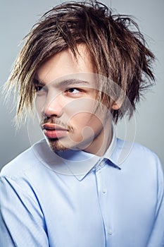 Portrait of young man with fringe messy hairstyle. studio shot