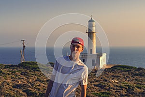 Young man in front of a lighthouse in Greece