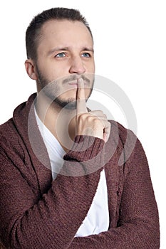 Portrait of young man gesturing silence sign on white background
