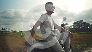 Portrait of young man in glasses sitting on motorcycle