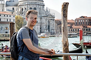 Portrait of a young man on the Grand Canal tram station. Basilica of Santa Maria della Salute on the background.