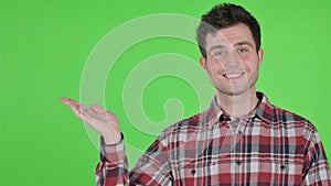 Portrait of Young Man Holding Product in Hand, Green Chroma Screen