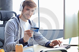 Portrait of a young man holds and using credit card for game money top up