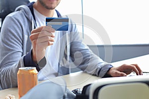 Portrait of a young man holds and using credit card for game money top up