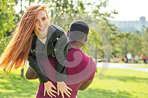 Portrait of young man hugging his girlfriend standing together on a spring summer park on a sunny day