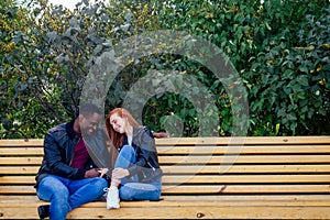 Portrait of young man hugging his girlfriend standing together on a spring summer park on a sunny day