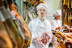 Portrait of young man jamoneria worker with pack of ham