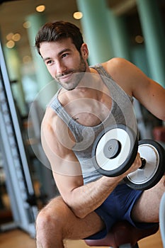 Portrait of a young man lifting weights in a fitness center
