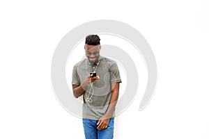 Young man listening to music with mobile phone and earphones against white background