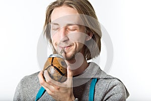 Portrait of young man with long blond hair on a white background