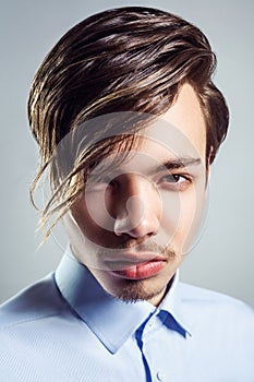 Portrait of young man with long fringe hairstyle on his eyes.