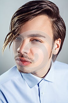 Portrait of young man with long fringe hairstyle on his eyes.