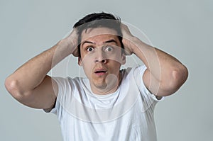 Portrait of a young man looking scared and shocked. Human expressions and emotions